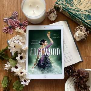 Edgewood book cover surrounded by Grimms Fairy tales, white candles, pine cones and beige flowers