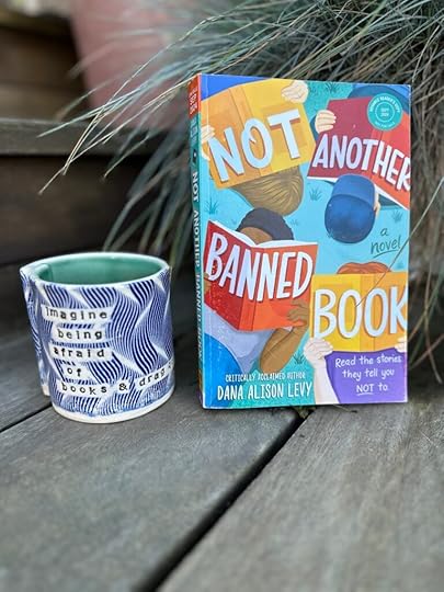 Copy of the book Not Another Banned Book next to a mug that says 