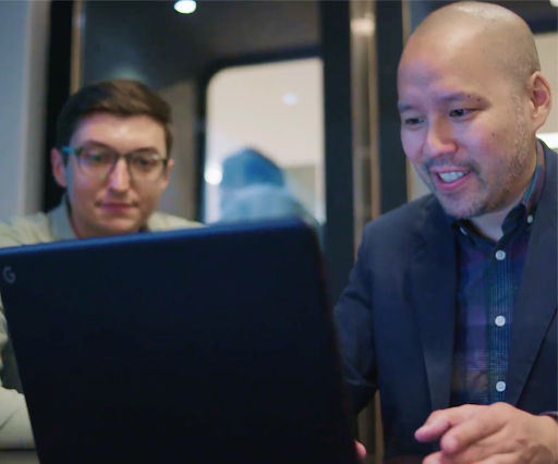 Two men looking at a laptop screen