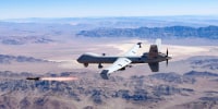 An Air Force MQ-9 Reaper fires a missile over the Nevada Test and Training Range at Nellis Air Force Base, on Aug. 30, 2023.