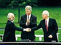 Raja Hussein dan PM Rabin berjabat tangan, diiringi oleh Presiden Clinton, semasa rundingan damai Israel-Jordan, 25 Julai 1994