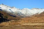 A ground view of a valley and several mountain tops.