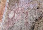 A picture of various red markings on a stone wall.