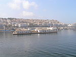 A skyline of a moderately large city, coloured mostly in white.