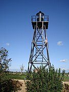 Photographie en couleurs d'un phare entouré par des végétations