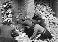 Armia Krajowa soldiers fighting during the Warsaw Uprising. One man is armed with Błyskawica machine pistol. Żołnierze Armii Krajowej w walkach podczas Powstania Warszawskiego, jeden używa pistolet maszynowy Błyskawica.