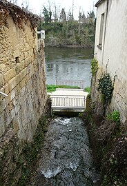 Ruisseau dans le bourg de Mouleydier. Au fond, la Dordogne dans laquelle il se jette.