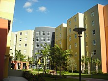 A six-story building painted in various bright shades with landscaped surroundings