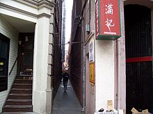 Fotografía de un callejón con un hombre caminando por él