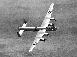 Four-engined military aircraft with twin tail fins in flight