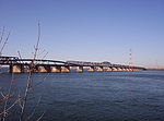 The numerous truss sections of a long bridge across a large body of water.