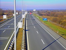 A view of the motorway from a flyover, a variable traffic sign gantry is visible