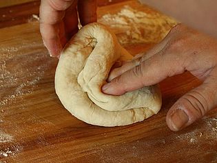 Pizza dough being kneaded. After this, it is typically left undisturbed and allowed time to proof.