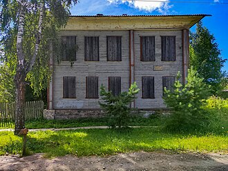 Photographie d'un bâtiment en bois blanc de deux étages.