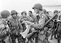 Six American paratroopers of the First Allied Airborne Army receive a final briefing from their commanding officer before emplaning. 17 September 1944