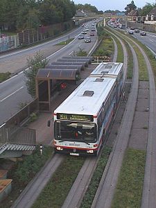 Ein älterer Spurbus auf der Spurbusstrecke inmitten der A40 – Haltestelle Feldhaushof