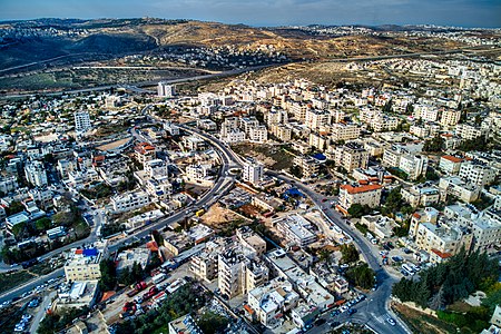 החלק המערבי של בית חנינא ומעבר לכביש ולגדר ההפרדה הכפר בית חנינא. מאחוריו באופק נבי סמואל, כשמשמאלו שכונת רמות ומימינו ביר נבאלה וגבעת זאב