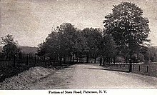 A black and white illustration of an unpaved highway flanked on both sides by fence and trees proceeds through mostly open land. A caption at the bottom reads "Picture of State Road, Patterson, N.Y."