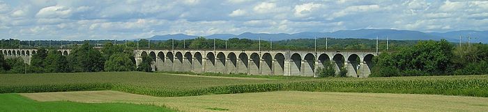 Photo panoramique du viaduc passant à une quinzaine de mètres au-dessus de la plaine.