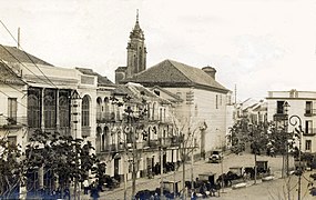 Español: Vista de la Plaza del Altozano de Utrera a principios del siglo XX. De izq a der: fachada del Casino, fachadas de viviendas del s. XVIII y Capilla de San Francisco (s. XVII). Este conjunto arquitectónico se conserva intacto en la actualidad. Русский: Капелла.