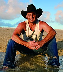 Man in black hat sitting on ground