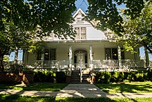 East Hall, a two-story wide-sided building with a covered porch across its front, in 2018