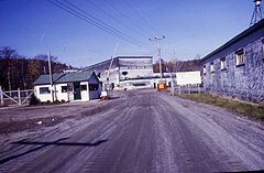 A road leading past a gatehouse to a series of industrial buildings