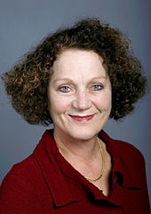 Portrait d'une femme aux cheveux bouclés bruns.