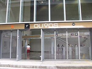 Picture of an entrance to the station, which is a metallic fence. The turnstiles can be seen in the background.