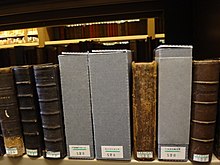 Série de livres disposés les uns à côté des autres sur une étagère. On peut voir leur cote numérique apposée au bas du dos des volumes.