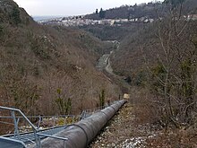 Photographie prise en plongé de la conduite forcée partant de la Durolle et montant jusque dans la montagne.