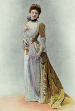 White woman with brown hair in 1900 evening dress with yellow-green velvet train