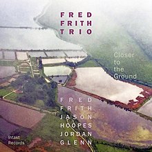 An aerial photograph of a country side, with the letters "Fred Frith Trio" at the center top, "Fred Frith Jason Hoopes Jordan Glenn" at the center bottom, and "Closer to the Ground" at the center right