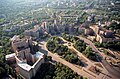 Freedom Square, Kharkiv in 2003, showing half of the square area (only the circular neighbouring park on the north-western edge). The square proper begins at the large statue of Lenin (this statue has since been removed). This statue of Lenin is seen in the lower right corner, casting a long shadow which points into the square.