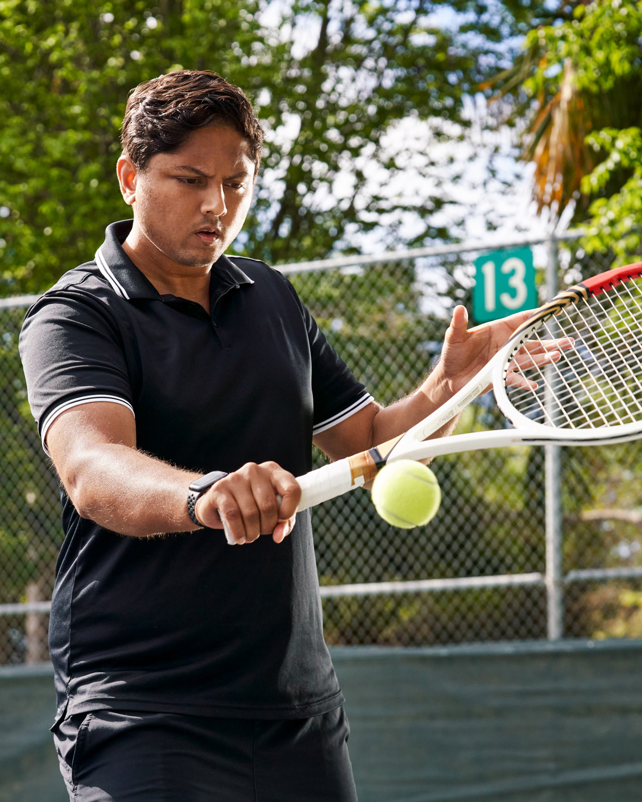 Swupnil Sahai frappant une balle en revers sur un court de tennis.