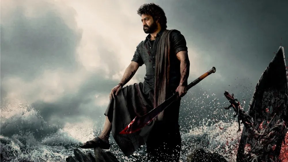 N.T. Rama Rao Jr. framed against a cloudy sky and rocky ocean on the promotional image for 'Devara: Part 1'