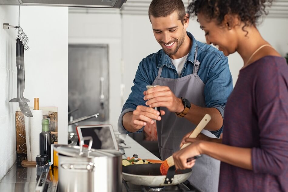 couple cooking dinner at stove